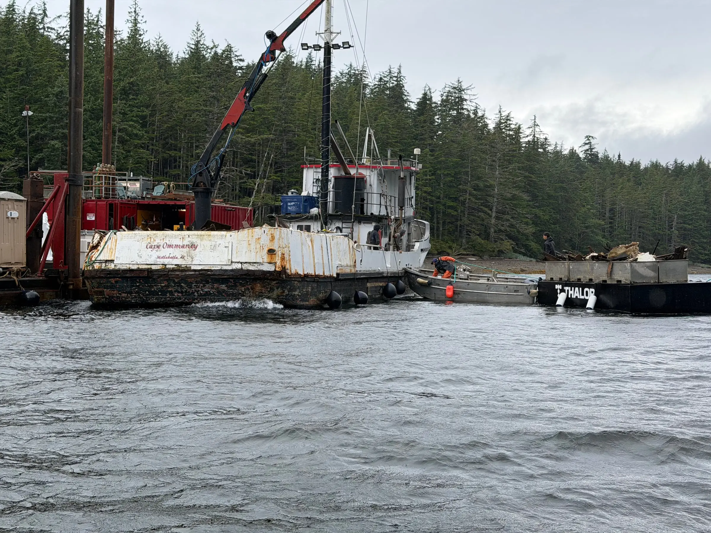 Ode alongside the derelict vessel Cape Ommaney as a crane barge works the cleanup